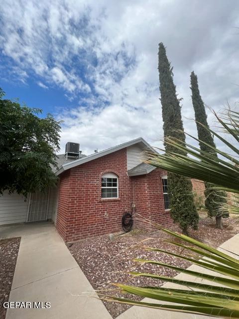 10256 Valle Suave Dr, El Paso, TX 79927 - view of side of home featuring brick siding and central AC
