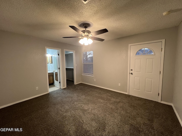 10256 Valle Suave Dr, El Paso, TX 79927 - foyer featuring a ceiling fan, dark carpet, a textured ceiling, and baseboards