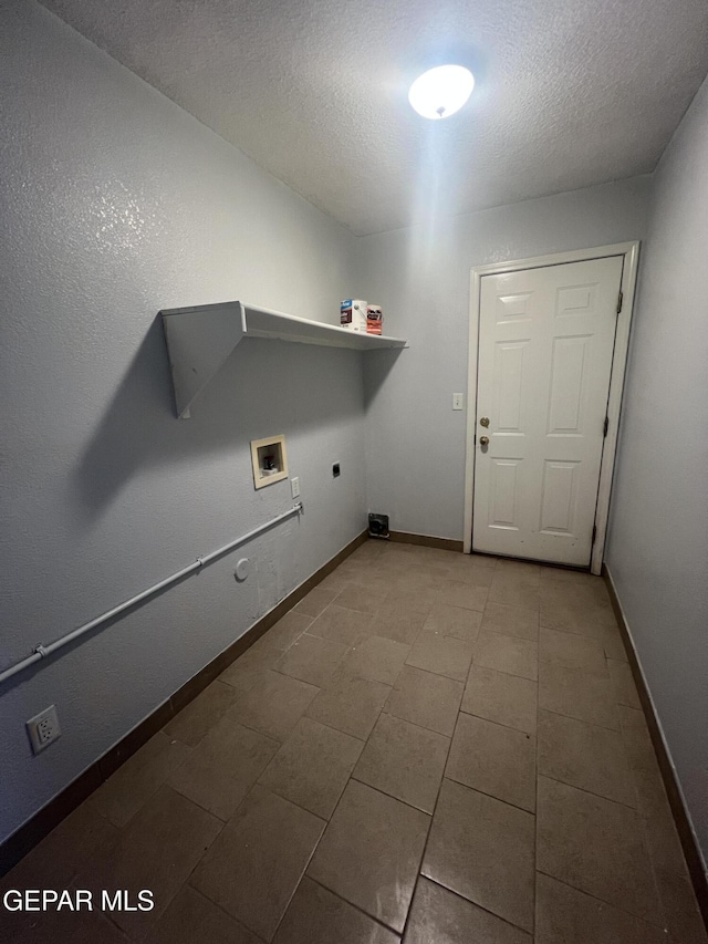 10256 Valle Suave Dr, El Paso, TX 79927 - laundry room with electric dryer hookup, washer hookup, baseboards, a textured ceiling, and tile patterned flooring
