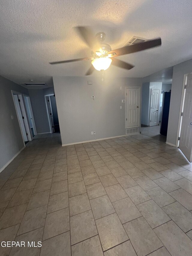10256 Valle Suave Dr, El Paso, TX 79927 - empty room with a textured ceiling, ceiling fan, baseboards, and light tile patterned floors