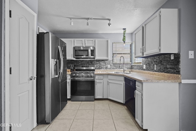 11457 David Carrasco Dr, El Paso, TX 79936 - kitchen with appliances with stainless steel finishes, a sink, a textured ceiling, light tile patterned floors, and rail lighting