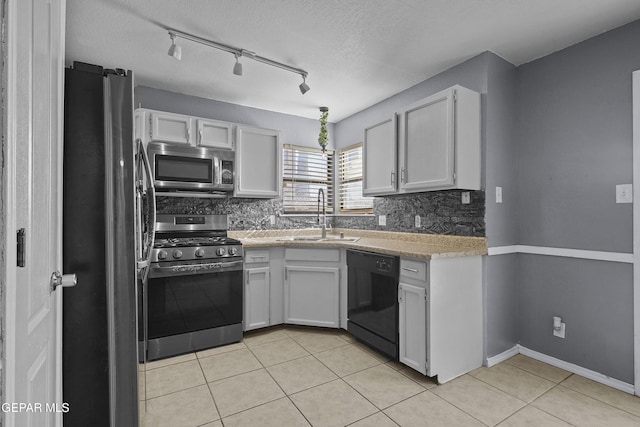 11457 David Carrasco Dr, El Paso, TX 79936 - kitchen with appliances with stainless steel finishes, a sink, light countertops, light tile patterned floors, and decorative backsplash