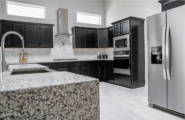 3920 Aspiration St, El Paso, TX 79938 - kitchen with stainless steel appliances, extractor fan, dark cabinetry, and decorative backsplash