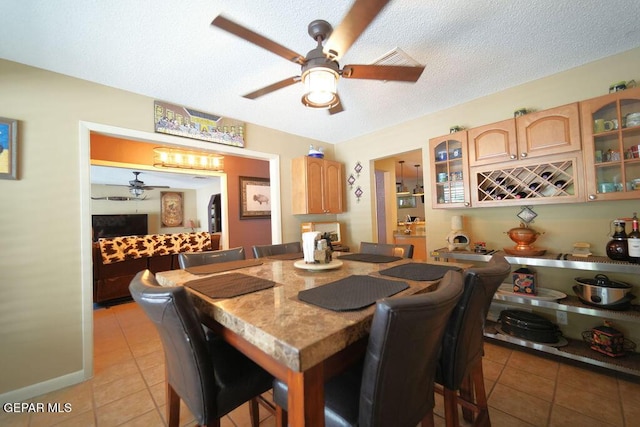 4313 Okeefe Dr, El Paso, TX 79902 - dining area with a ceiling fan, light tile patterned floors, a textured ceiling, and a bar