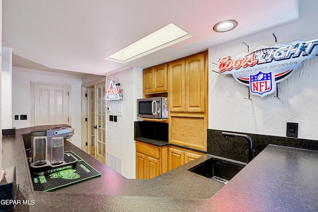 5500 Rancho Sereno Pl, El Paso, TX 79932 - kitchen with a sink, stainless steel microwave, and dark countertops