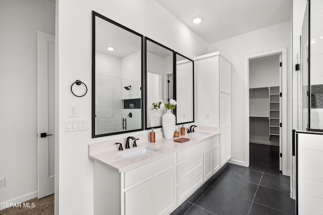 13380 Coldham St, El Paso, TX 79928 - bathroom with a tile shower, double vanity, baseboards, a spacious closet, and tile patterned floors