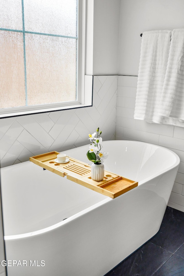13380 Coldham St, El Paso, TX 79928 - bathroom featuring tile walls, a freestanding tub, and tile patterned floors