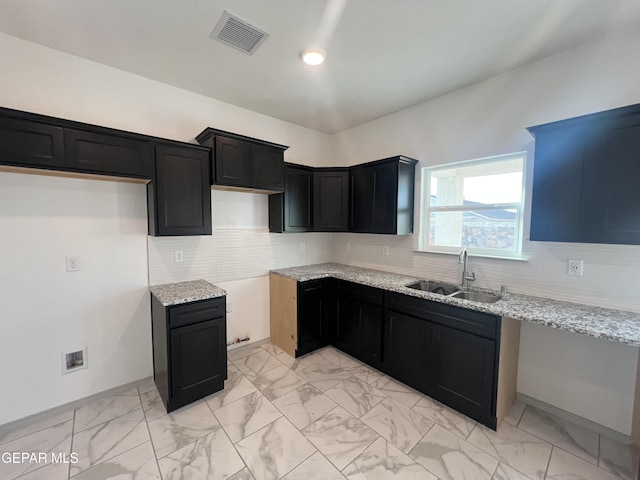 15221 Apex Ct, El Paso, TX 79938 - kitchen featuring a sink, light marble finish flooring, light stone countertops, decorative backsplash, and dark cabinets