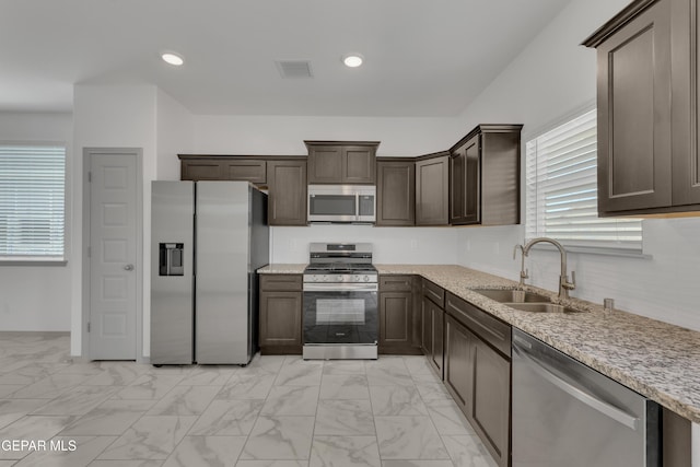 15221 Apex Ct, El Paso, TX 79938 - kitchen featuring appliances with stainless steel finishes, dark brown cabinets, light marble finish floors, healthy amount of natural light, and recessed lighting