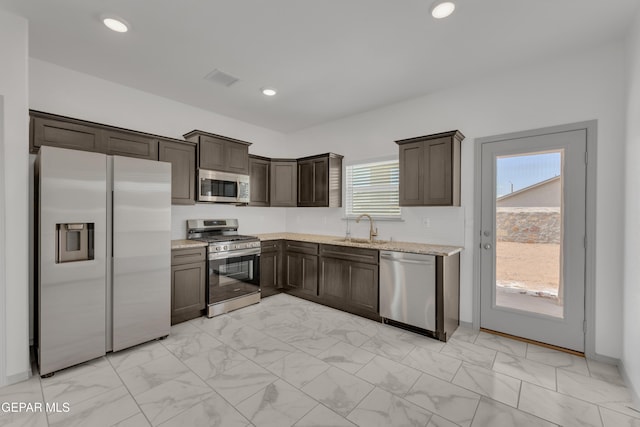 15221 Apex Ct, El Paso, TX 79938 - kitchen with stainless steel appliances, light marble finish floors, dark brown cabinets, light stone countertops, and recessed lighting