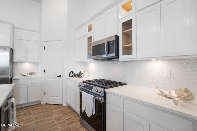891 Dewsbury Way, El Paso, TX 79928 - kitchen with stainless steel appliances, white cabinets, light countertops, tasteful backsplash, and wood finished floors
