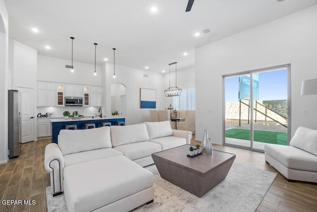 891 Dewsbury Way, El Paso, TX 79928 - living area with arched walkways, light wood-type flooring, a high ceiling, and recessed lighting