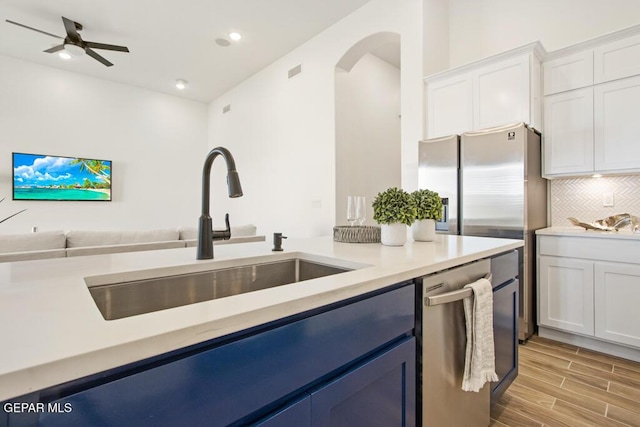 891 Dewsbury Way, El Paso, TX 79928 - kitchen featuring a sink, stainless steel appliances, arched walkways, decorative backsplash, and white cabinetry