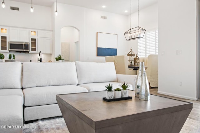 891 Dewsbury Way, El Paso, TX 79928 - living room with arched walkways, light wood-style floors, baseboards, and recessed lighting