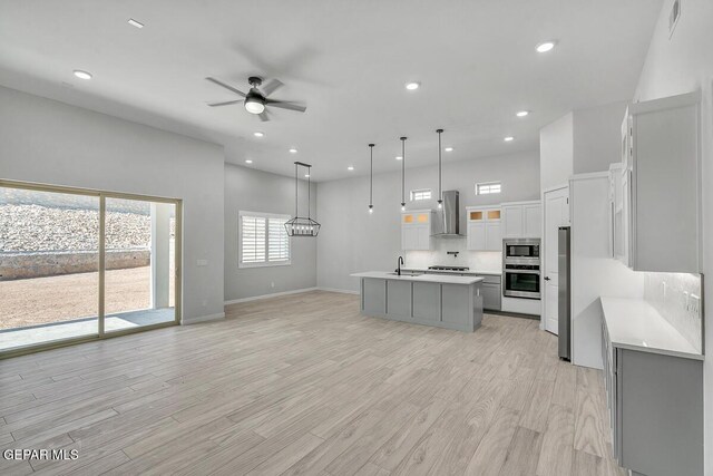 899 Dewsbury Way, El Paso, TX 79928 - kitchen with a sink, light countertops, a ceiling fan, backsplash, and wall chimney exhaust hood
