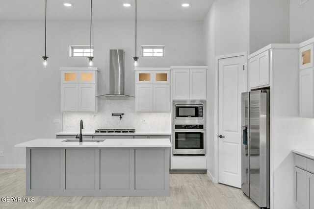 899 Dewsbury Way, El Paso, TX 79928 - kitchen featuring appliances with stainless steel finishes, island range hood, decorative backsplash, light countertops, and a center island with sink