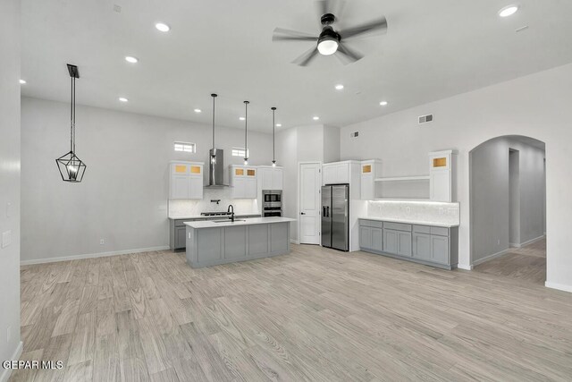 899 Dewsbury Way, El Paso, TX 79928 - kitchen with wall chimney range hood, stainless steel refrigerator with ice dispenser, arched walkways, a sink, and light countertops