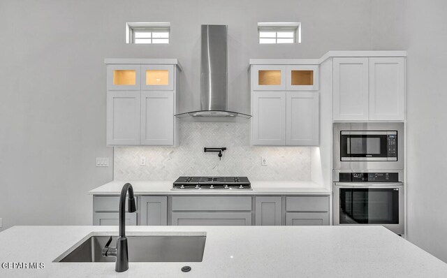 899 Dewsbury Way, El Paso, TX 79928 - kitchen with appliances with stainless steel finishes, wall chimney exhaust hood, a sink, and glass insert cabinets