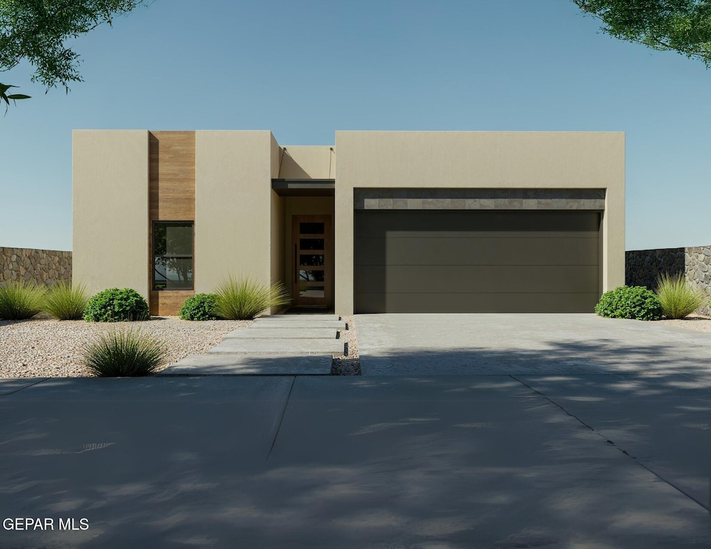 953 Ada Ln, El Paso, TX 79932 - view of front of home featuring a garage, stucco siding, and driveway