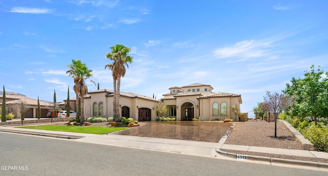 6572 Tuscany Ridge Dr, El Paso, TX 79912 - mediterranean / spanish-style home with curved driveway, stucco siding, and a tiled roof