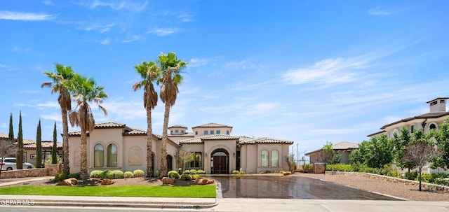 6572 Tuscany Ridge Dr, El Paso, TX 79912 - mediterranean / spanish house with stucco siding, curved driveway, and a tile roof