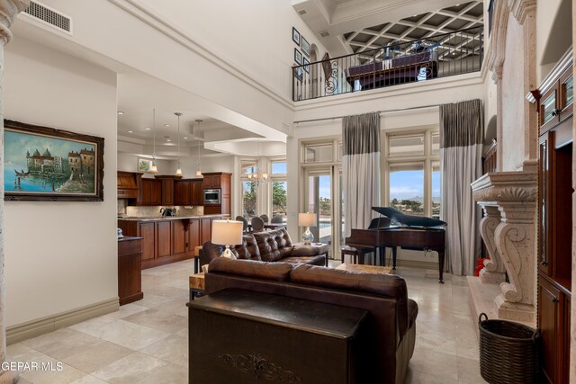 6572 Tuscany Ridge Dr, El Paso, TX 79912 - living area with coffered ceiling, light tile patterned flooring, a high ceiling, a fireplace, and beamed ceiling
