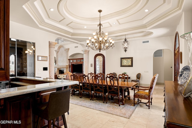 6572 Tuscany Ridge Dr, El Paso, TX 79912 - dining space featuring arched walkways, a raised ceiling, crown molding, a fireplace, and a chandelier