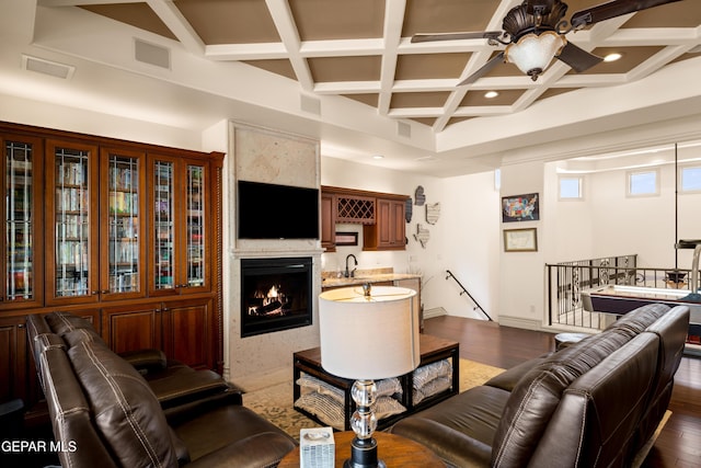 6572 Tuscany Ridge Dr, El Paso, TX 79912 - living room featuring coffered ceiling, a ceiling fan, a fireplace with flush hearth, beamed ceiling, and dark wood-type flooring