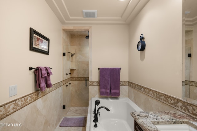 6572 Tuscany Ridge Dr, El Paso, TX 79912 - bathroom with tile walls, a garden tub, a shower stall, vanity, and wainscoting