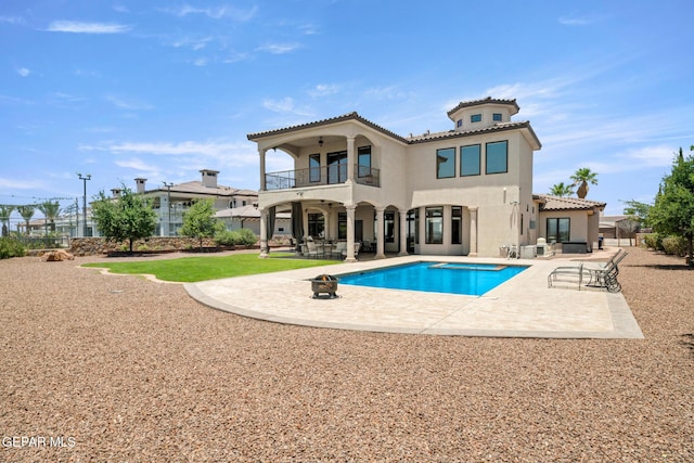 6572 Tuscany Ridge Dr, El Paso, TX 79912 - rear view of house with a balcony, a patio area, stucco siding, an outdoor pool, and a tiled roof