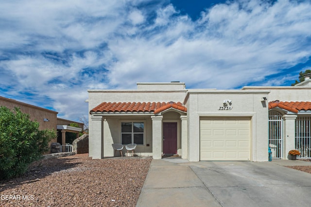 7573 Le Conte Dr Unit A, El Paso, TX 79912 - view of front of property with concrete driveway, stucco siding, a tile roof, an attached garage, and central air condition unit