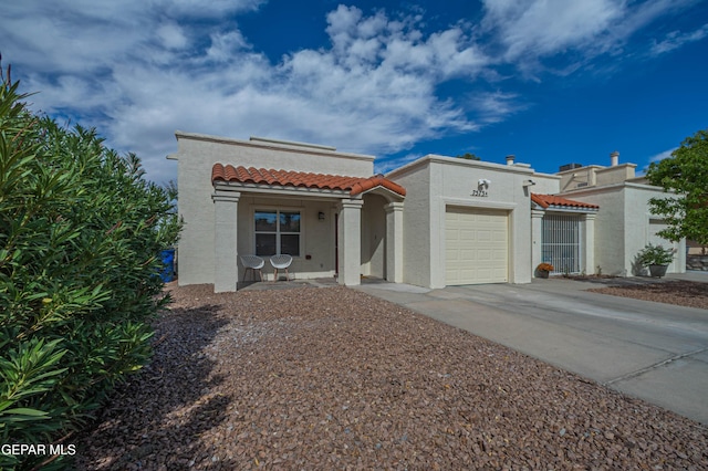 7573 Le Conte Dr Unit A, El Paso, TX 79912 - mediterranean / spanish-style house featuring stucco siding, a tiled roof, a garage, and driveway