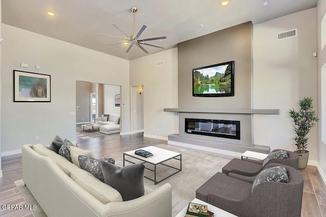 1857 War Path Dr, El Paso, TX 79911 - living room featuring ceiling fan, wood finished floors, a glass covered fireplace, baseboards, and recessed lighting