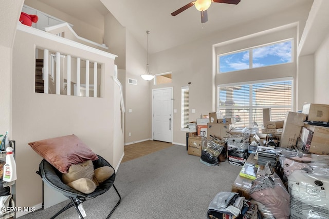 7101 Mesquite Tree Ln, El Paso, TX 79934 - carpeted living room with a ceiling fan, a towering ceiling, tile patterned flooring, and baseboards