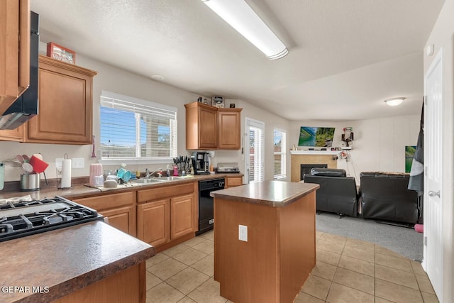 7101 Mesquite Tree Ln, El Paso, TX 79934 - kitchen featuring dishwasher, open floor plan, a center island, light tile patterned floors, and a tiled fireplace