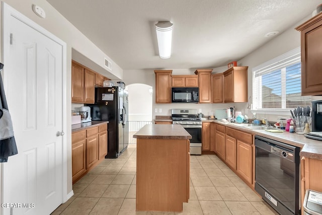 7101 Mesquite Tree Ln, El Paso, TX 79934 - kitchen featuring black appliances, a center island, arched walkways, a sink, and light tile patterned floors