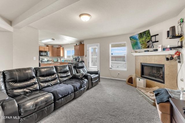 7101 Mesquite Tree Ln, El Paso, TX 79934 - living area featuring light carpet, a tiled fireplace, and baseboards