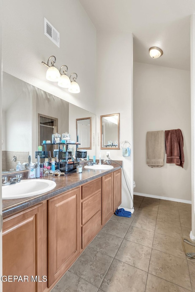 7101 Mesquite Tree Ln, El Paso, TX 79934 - bathroom with double vanity, tile patterned flooring, toilet, a high ceiling, and baseboards