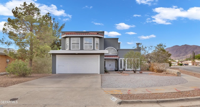 6101 Via Suerte Ave, El Paso, TX 79912 - view of front of property with stucco siding, a tile roof, a garage, concrete driveway, and a mountain view
