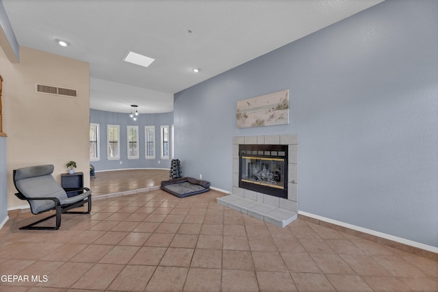 6101 Via Suerte Ave, El Paso, TX 79912 - unfurnished living room featuring a tiled fireplace, light tile patterned floors, baseboards, and recessed lighting
