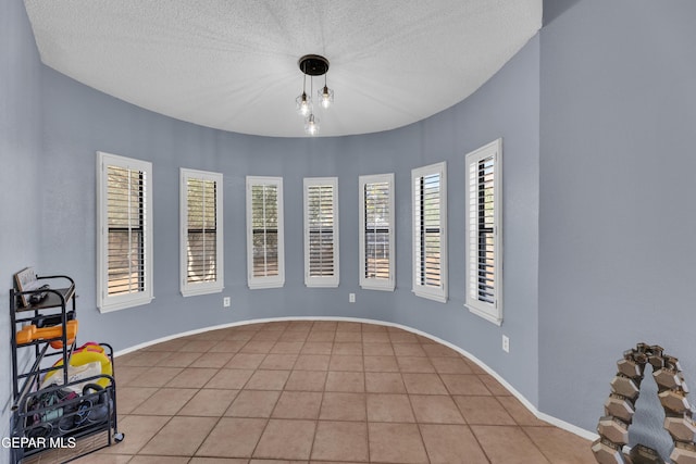 6101 Via Suerte Ave, El Paso, TX 79912 - spare room with light tile patterned floors, a textured ceiling, and baseboards