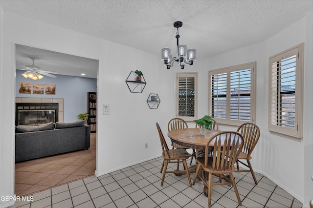 6101 Via Suerte Ave, El Paso, TX 79912 - dining area with a textured ceiling, a chandelier, a ceiling fan, baseboards, and a fireplace