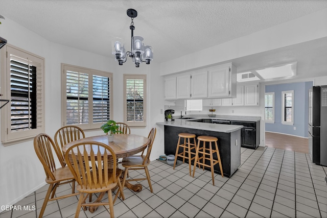 6101 Via Suerte Ave, El Paso, TX 79912 - dining space featuring a chandelier, baseboards, a textured ceiling, and light tile patterned floors