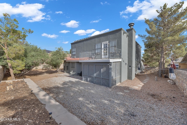 6101 Via Suerte Ave, El Paso, TX 79912 - back of house with a balcony, stucco siding, and a chimney