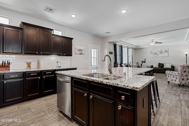 12749 Iron Falls Dr, Horizon City, TX 79928 - kitchen featuring a sink, dishwasher, open floor plan, an island with sink, and a kitchen breakfast bar