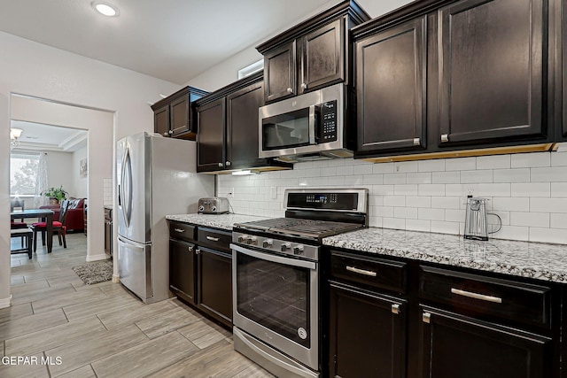 12749 Iron Falls Dr, Horizon City, TX 79928 - kitchen featuring stainless steel appliances, backsplash, light stone countertops, light wood-style floors, and dark brown cabinets