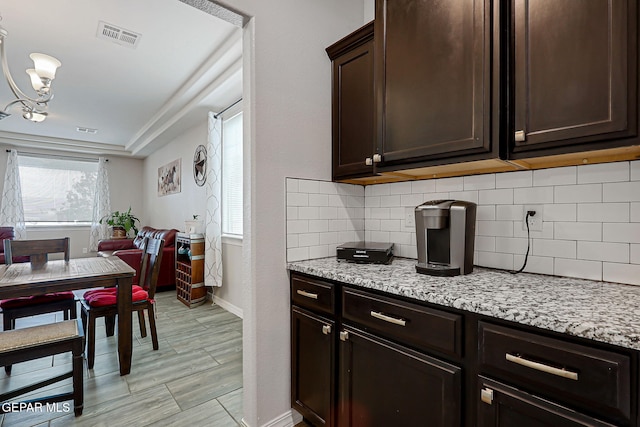 12749 Iron Falls Dr, Horizon City, TX 79928 - kitchen with dark brown cabinetry, baseboards, and backsplash