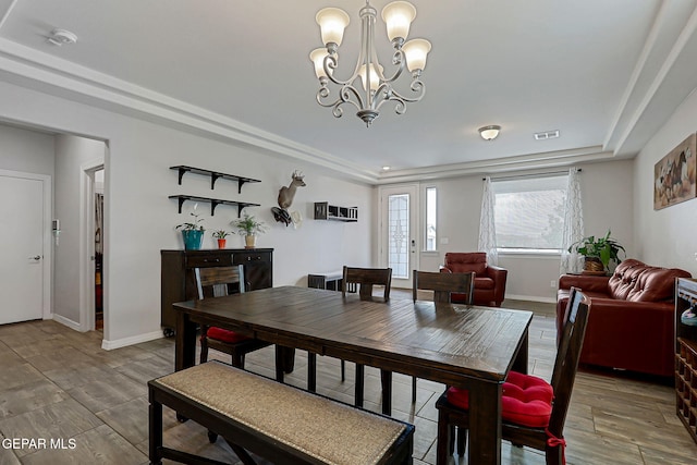 12749 Iron Falls Dr, Horizon City, TX 79928 - dining area with a chandelier, light wood finished floors, baseboards, and a raised ceiling