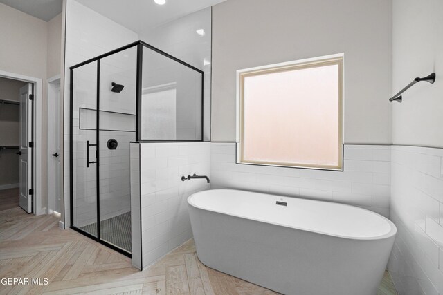 13351 Jeff Winton Dr, El Paso, TX 79928 - bathroom with tile walls, a soaking tub, a stall shower, a walk in closet, and wainscoting