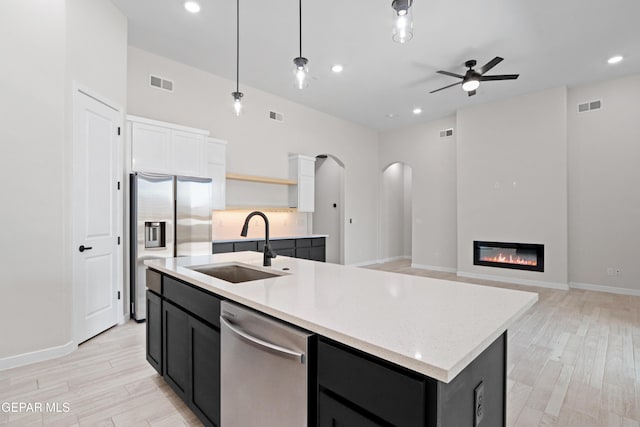 13351 Jeff Winton Dr, El Paso, TX 79928 - kitchen with stainless steel appliances, arched walkways, a sink, ceiling fan, and open shelves